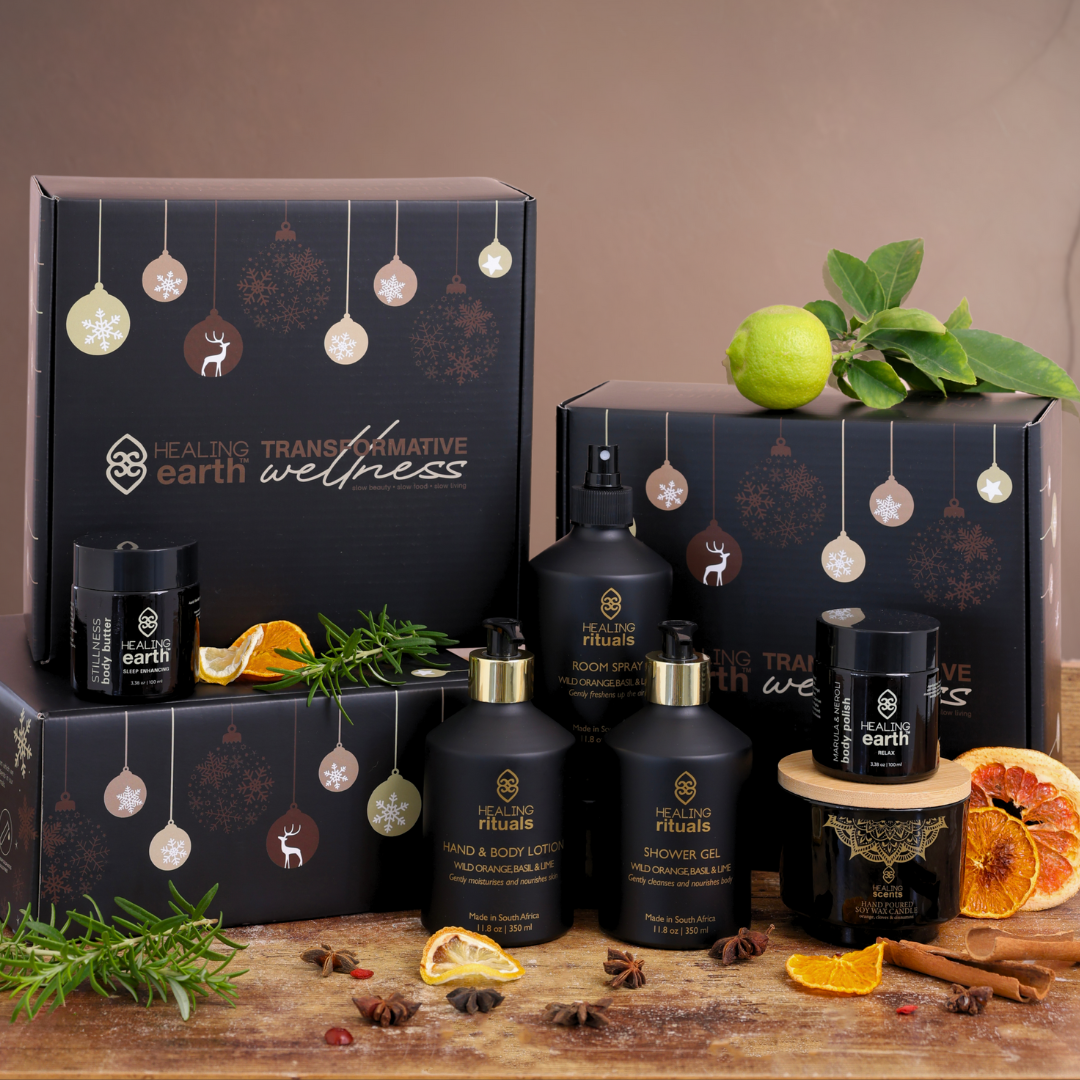 Healing Earth Transformative Wellness products gift set set with bottles, containers, and decorative elements on a wooden surface.